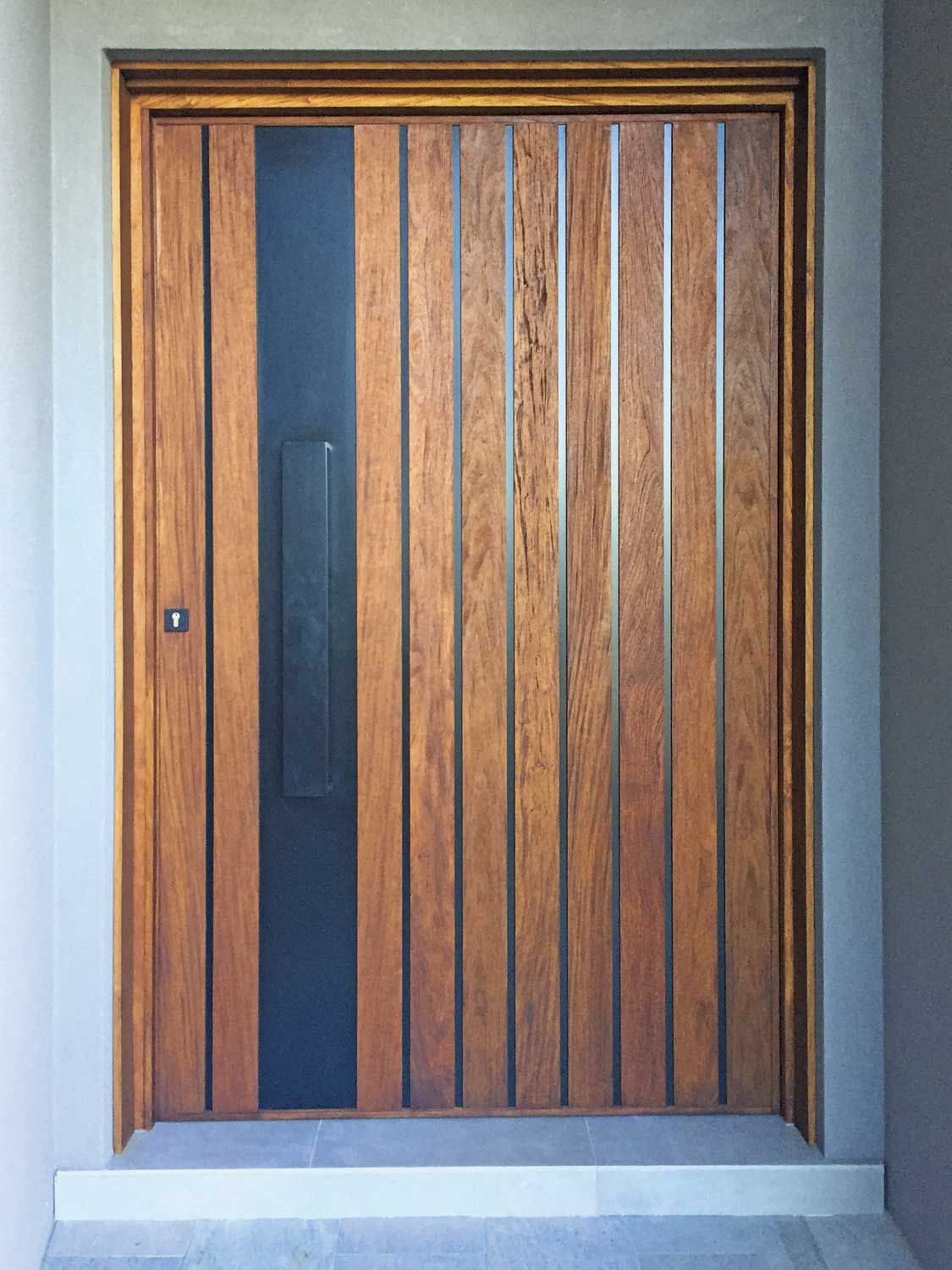 Powder coated vertical metallic strip with incorporated handle custom pivot door